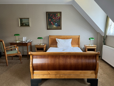 Haus Thal - Zimmer 2  Gemütliches Hotelzimmer mit Holzbett, zwei Nachttischen, einem Schreibtisch und stimmungsvoller Dekoration.