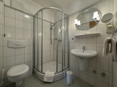Haus Thal - Zimmer 1 - Badezimmer Kompaktes, modernes Badezimmer mit Dusche, Toilette, Waschbecken, Spiegel und weichen Handtüchern.