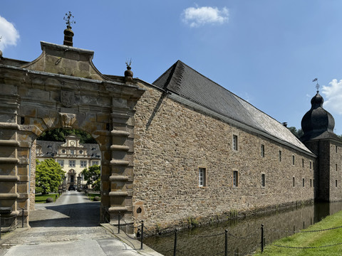 Schloss Ehreshoven Historisches Schloss mit imposantem Torbogen, umgeben von Wassergraben und gepflegter Gartenanlage.