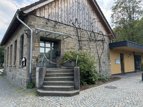 Engel-Museum Eingangsbereich Gemäuer aus Stein mit modernen Anbau, breiten Stufen und gepflastertem Vorplatz in ruhiger Umgebung.