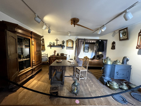 Bergisches Museum für Bergbau, Handwerk und Gewerbe Historisches Zimmer mit Holzschränken, Eisenöfen und Dekorationen im Retro-Stil auf Holzboden.