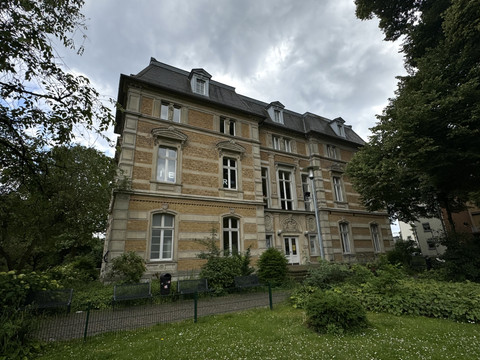 Kunstmuseum Villa Zanders Historisches, dreistöckiges Gebäude mit schiefergedecktem Dach, umgeben von begrüntem Garten.