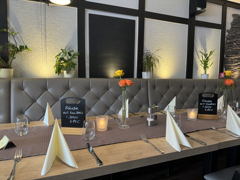 Restaurant Zum Holländer - Innenansicht Ein stilvoll gedeckter Tisch in einem Restaurant mit Kerzen und Blumendekoration.