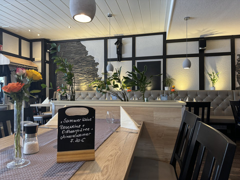 Restaurant zum Holländer - Innenansicht Gemütliches Restaurant mit stilvoller Tischdekoration, Blumen und Speiseschild in einladender Atmosphäre.