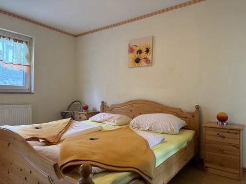 Gasthof Zum Stausee Ein gemütliches Schlafzimmer mit zwei Einzelbetten aus Holz, jeweils mit gelben Decken.