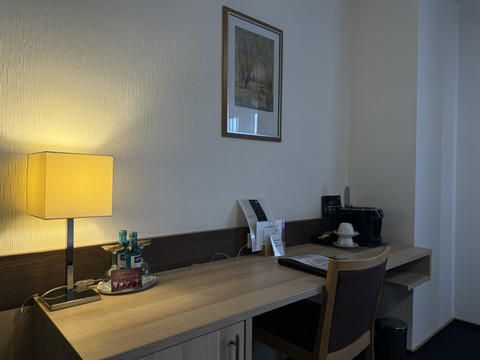 Hotel-Restaurant Zum Holländer - Ansicht Doppelzimmer  Arbeitsbereich in einem Hotelzimmer mit Schreibtisch, Lampe, Stuhl und Kaffeestation.