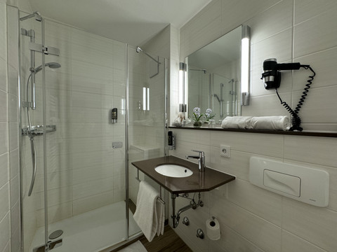 Hotel-Restaurant Zum Holländer - Ansicht Doppelzimmer - Badezimmer Ein modernes, barrierefreies Badezimmer mit ebenerdiger Dusche, Waschbecken und Handtuchhalter.