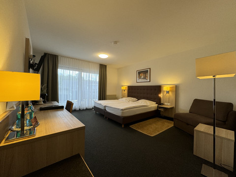 Hotel-Restaurant Zum Holländer - Ansicht Doppelzimmer 2 Schönes, modern eingerichtetes Hotelzimmer mit Doppelbett, Schreibtisch, Sofa und Balkon im Hintergrund.
