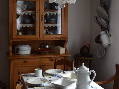 Bauernhofmuseum Eine gemütliche Landhausküche mit gedecktem Tisch und vintage Porzellangeschirr.