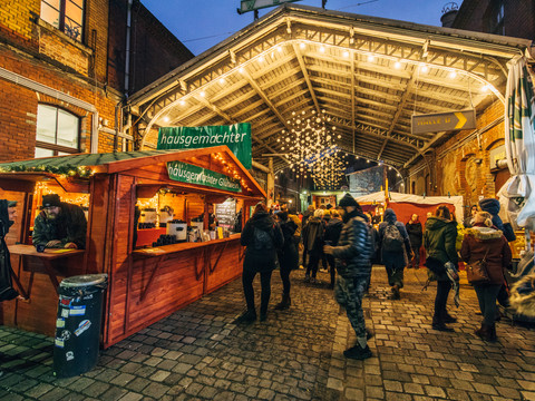 Weihnachtsmarkt am Connewitzer Kreuz - Weihnachten in Leipzig Blick auf einen Glühweinstand vor der beleuchteten Kulisse am Connewitzer Kreuz am AbendView of a mulled wine stand in front of the illuminated backdrop at Connewitzer Kreuz in the eveningPohled na stánek se svařeným vínem před osvětlenou kulisou na Connewitzer Kreuz ve večerních hodináchWidok stoiska z grzanym winem przed oświetlonym tłem w Connewitzer Kreuz wieczoremZicht op een glühweinkraam voor het verlichte decor van het Connewitzer Kreuz 's avondsVista di uno stand di vin brulé davanti allo sfondo illuminato del Connewitzer Kreuz di sera
