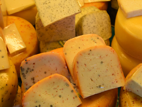 Thomashof Burscheid  Käselaib mit Pfefferschoten und Kräutern verziert, aufgeschnittene Stücke zeigen die bunte Textur.