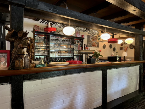 Landhaus Orbach Bar Gemütliche Bar mit rustikalem Charme, Holzdekor, beleuchteten Regalen voller Gläser und Dekorobjekten.