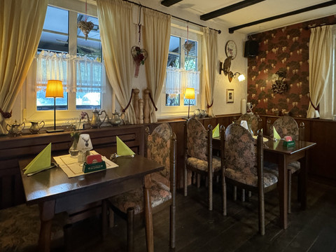 Landhaus Orbach Innenansicht Gemütlicher, rustikal eingerichteter Gastraum mit dekorierten Tischen und warmem, gedämpftem Licht.