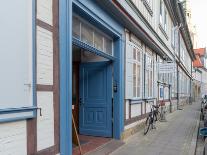 Hofcafé Eingang Geöffnete, zweiflügelige, blaue Tür in einem Fachwerkhaus. Am Haus hängt ei Schild auf dem "Hofcafé" steht.