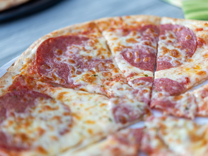 L'Oliveto Pizza Nahaufnahme einer geschnittenen Salamipizza auf einem Teller