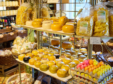 Hofladen Hielscher Hof  Käseauswahl in einem Feinkostgeschäft, präsentiert in rustikalem Ambiente.