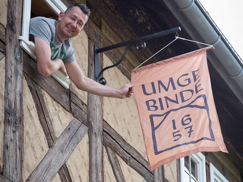 Flagge mit Logo am Haus