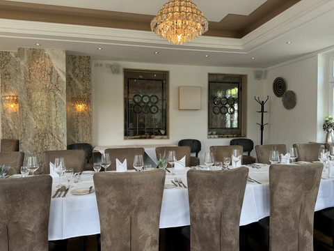 Innenansicht Elegantes Restaurant mit gedecktem Tisch, Kronleuchter und moderner Wanddekoration.