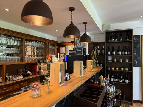 In der Delling <p>Gemütliche Bar mit Holztheke, dekorativen Gläsern und Weinregalen an den Wänden.</p>
