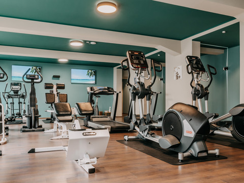 Fitnesspark (5).jpg Helles, modern ausgestattetes Fitnessstudio mit Laufbändern, Rudergeräten und Cardiofitnessgeräten.
