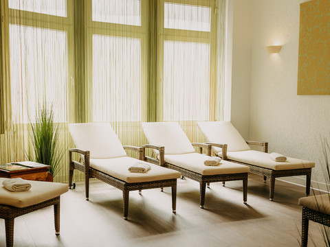 Wellness (1).jpg Fünf bequeme Liegen in einem ruhigen, hellen Raum mit großen Fenstern und entspannendem Ambiente.
