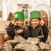 zwei Kinder in Bergbauuniform, an einem Erzhunt in der Bergbauausstellung des Stadt- und Bergbaumuseums Freiberg stehend