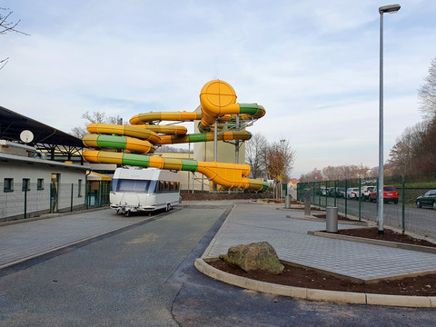 Caravanstellplatz - im Hintergrund die Rutschen des Erlebnisbades im "Hains"