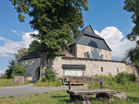 Wehrkirche Triebel mit Sitzgruppe und Informationstafel für Wanderer