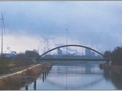 Blick von der Fußgängerbrücke nach Süden. Im Vordergrund die 1972 errichtete Straßenbrücke der Industriestraße Nord und im Bildhintergrund einige markante Bauten des Hüttenwerks.