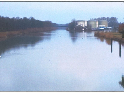 Blick von der Fußgängerbrücke nach Norden. Im Bildvordergrund die Einfahrt zum Hafen Beddingen und das Tanklager der Firma THS Mineralölumschlag GmbH.