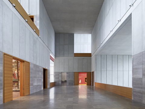 Large, bright room with high ceilings, gray walls and wooden elements in the museum.