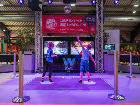 iWall Zwei Kinder interagieren mit einem iWall-Spiel in einem modernen Entertainment-Zentrum.Two children interact with an iWall game in a modern entertainment center.Interakce dvou dětí s hrou iWall v moderním zábavním centru.Dwoje dzieci korzysta z gry iWall w nowoczesnym centrum rozrywki.Twee kinderen spelen een iWall-game in een modern entertainmentcentrum.Due bambini interagiscono con un gioco iWall in un moderno centro di intrattenimento.