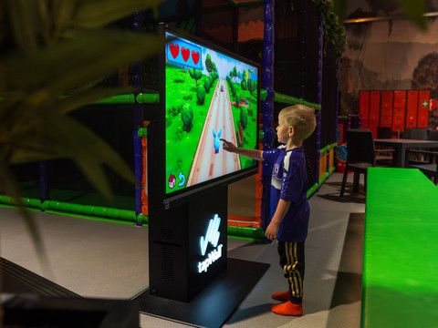 tapWall Ein Kind spielt mit einem interaktiven Bildschirm im Indoor-Freizeitbereich.A child plays with an interactive screen in the indoor leisure area.Dítě si hraje s interaktivní obrazovkou ve vnitřním prostoru pro volný čas.Dziecko bawi się interaktywnym ekranem w wewnętrznej strefie rekreacyjnej.Een kind speelt met een interactief scherm in de overdekte ontspanningsruimte.Un bambino gioca con uno schermo interattivo nell'area ricreativa interna.