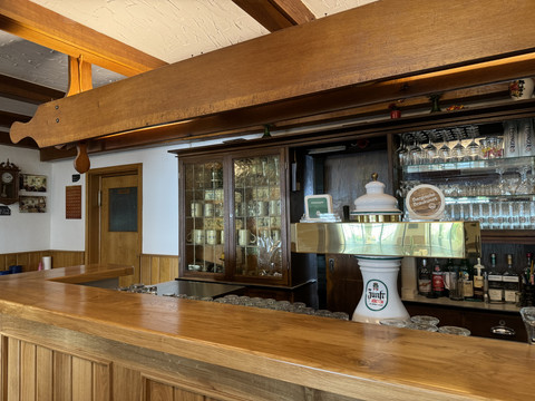 Landhaus Fuchs - Ansicht Bar Gemütlicher Tresen einer traditionellen Gaststätte in Holzoptik mit Zapfanlage und Gläsern.
