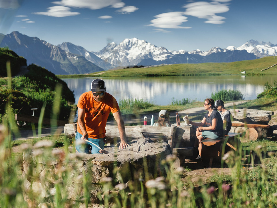 Familie am braeteln bei der Feuerstelle Bettmersee