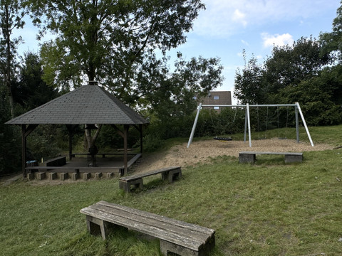Jugendherberge Radevormwald - Ansicht Spieplatz <p>Spielplatz mit Holzbank, Schaukeln und Pavillon im grünen Umfeld, ideal für Erholung im Freien.</p>