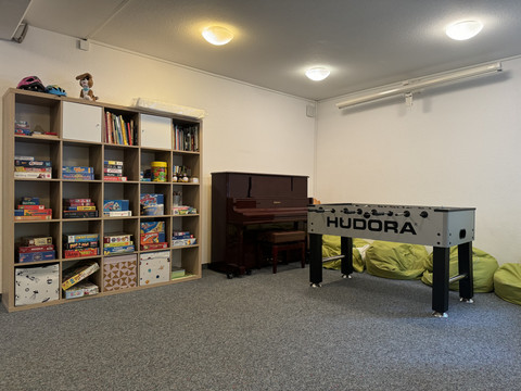 Jugendherberge Radevormwald - Ansicht Aufenthaltsraum Ein Spielraum mit Tischfußball, Piano und Regal voller Spiele in Radevormwald.