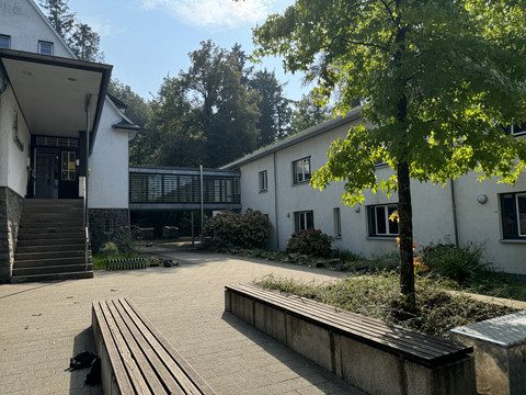Jugendherberge Radevormwald - Außenansicht Zweigeschossiges Gebäude im Grünen mit moderner Brücke und einladendem Vorplatz in Radevormwald.
