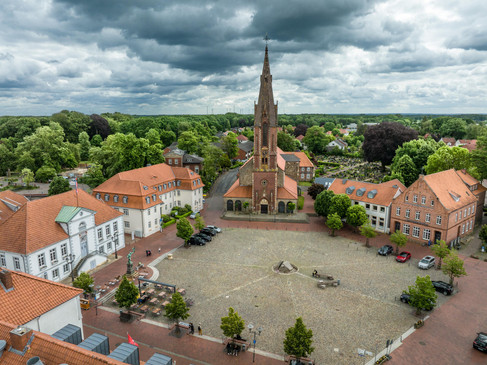 Luchtfoto van een historisch marktplein met een indrukwekkende kerk in het midden.