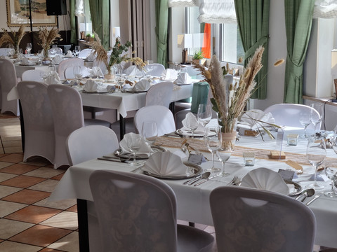 Uelfetal_1.jpg Elegant gedecktes Restaurant mit weißem Tischtuch, feinen Weingläsern und stilvoller Dekoration.