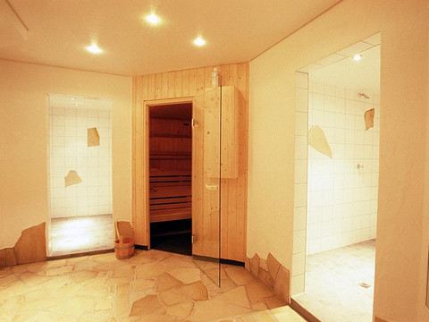 Jugendherberge Wiehl Innenansicht eines Wellnessbereichs mit Sauna, Fliesenwänden und gefliesten Duschkabinen.