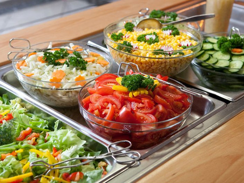 Jugendherberge Wiehl Frische Salatbar mit Schüsseln voll bunter Salate, Tomaten, Gurken, Mais und Krautsalat auf Edelstahltheke.
