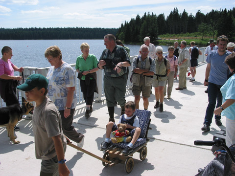 Wandergruppe beim Überqueren der Staumauer der Talsperre Carlsfeld