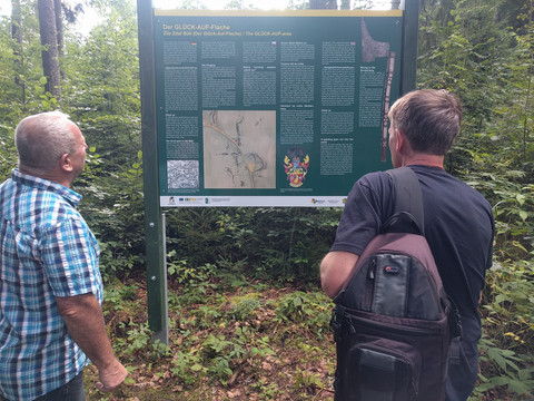 Besucher an Infotafel am Rundweg