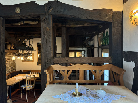 Pfannkuchenhaus Nümbrecht - Innenansicht Ein rustikales, gemütliches Interieur eines historischen Gasthauses mit Holzverkleidungen und antikem Mobiliar.
