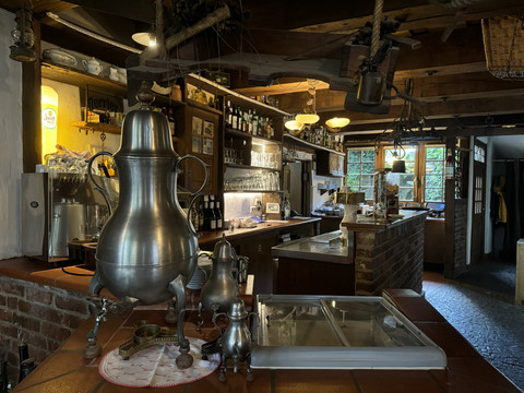 Pfannkuchenhaus Nümbrecht - Ansicht große Dröppelminna Gemütliches Café mit rustikalem Charme, dekoriert mit antiken Teekannen und Holzelementen.