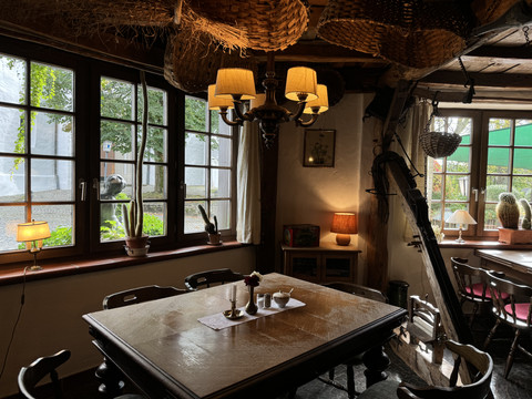 Pfannkuchenhaus Nümbrecht - Innenansicht Gemütliches, rustikales Café mit Holztischen, gemütlicher Beleuchtung und charmantem Landhausstil.
