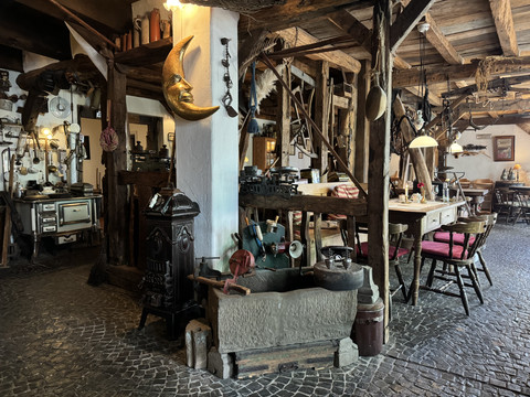 Pfannkuchenhaus Nümbrecht - Innenansicht Rustikales Gasthausinterieur mit Holzbalken, antikem Herd, Holztischen und gemütlichen Sitzgelegenheiten.