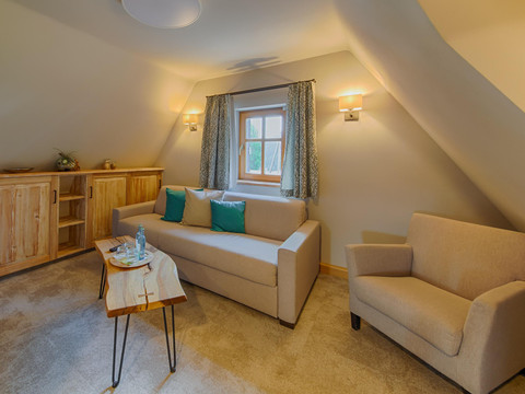 Bärensuite - Wohnraum mit Schafcouch und Kamin