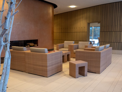 Sauna Foyer Vorraum des Saunabereichs mit Sesseln in warmen Farben und einer Tür zum Ruhebereich.